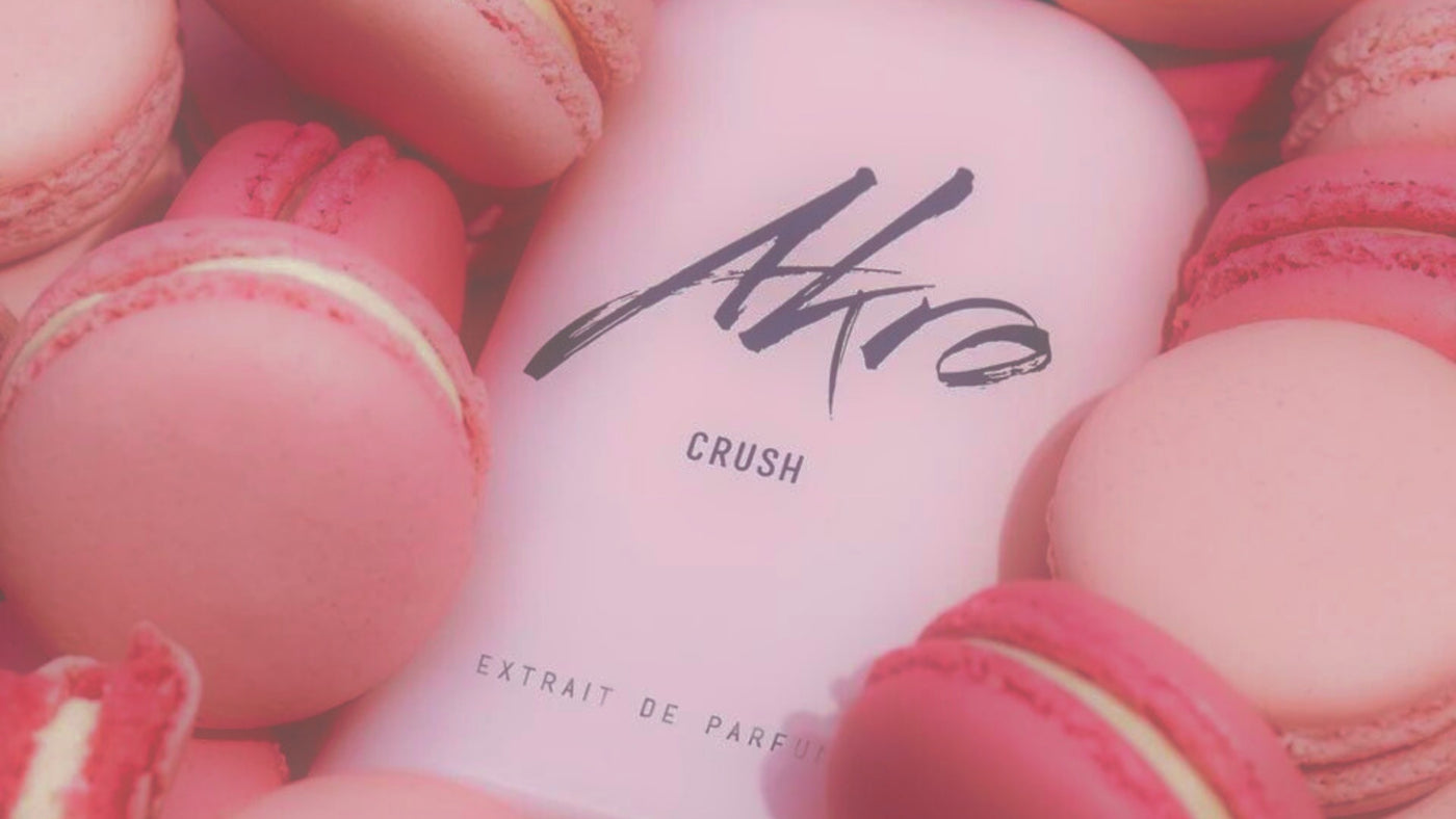 Close-up of Akro Crush pink perfume bottle lying in a pile of pink macarons.