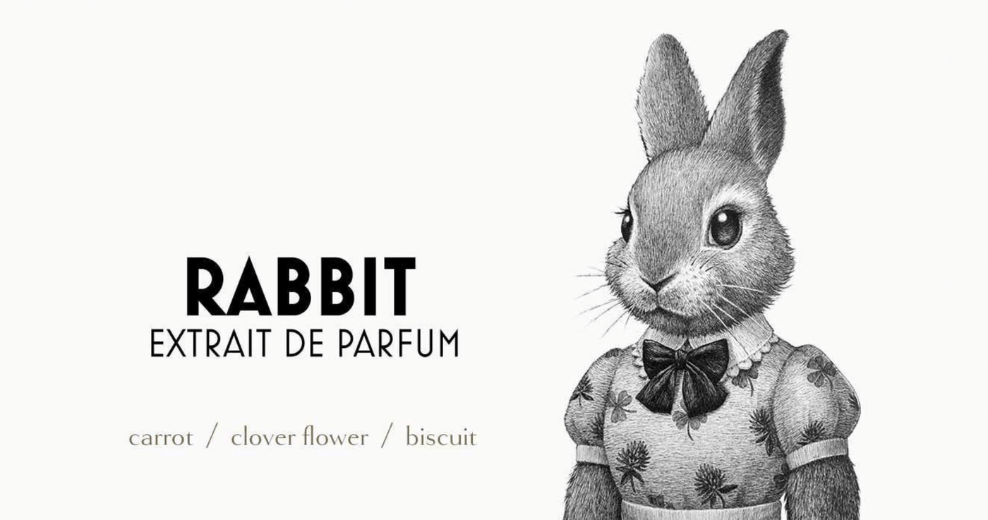 Black and white illustration of the Zoologist Rabbit character, next to the words "Rabbit Extrait de Parfum" and "Carrot / Clover Flower / Biscuit"