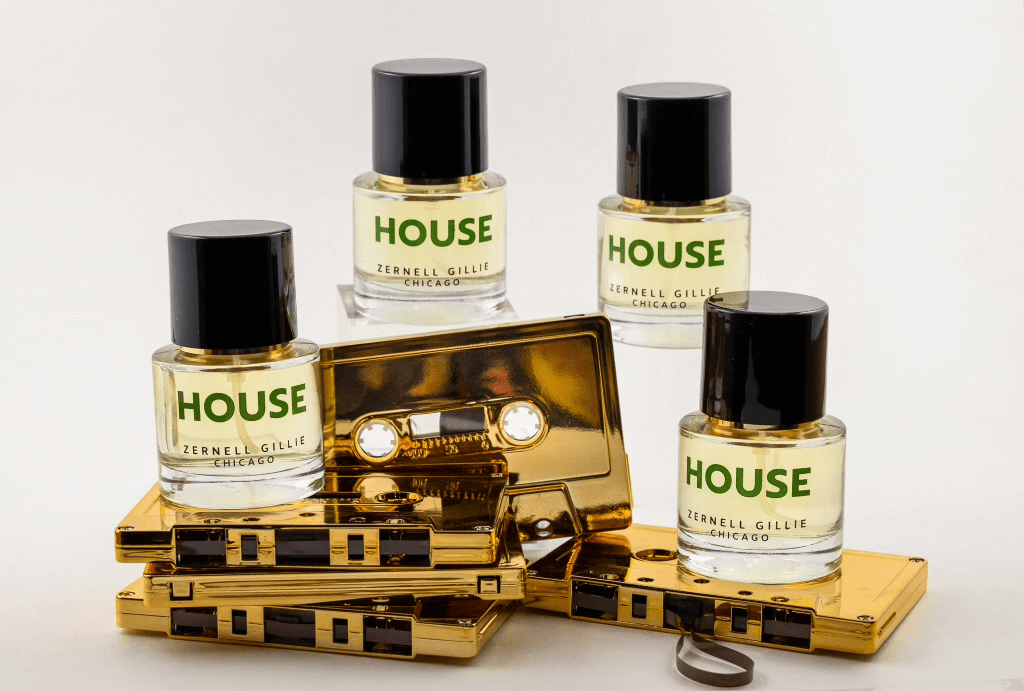 Four bottles of Zernelle Gillie's House extrait de parfum, in 30ml cylindrical bottles. Bottles are posed on a stack of metallic gold cassette tapes. 